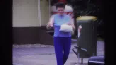 Paris France (1967): A Woman Walking Out To Her Care Carrying Two Items/