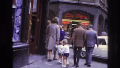 Paris France (1967): Two Boys Walk On Busy City Sidewalk While Cars Pass On The