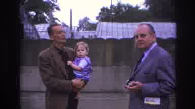 Paris France (1967): Man Holding Baby Talking To Another Man, Car Driving