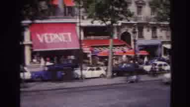 PARIS FRANCE-1967: Vernet Shop, Classic Cars, and Pedestrians on a Tree-lined Street