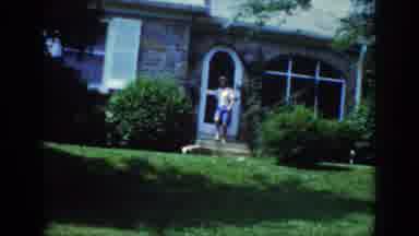 Raleigh North Carolina USA (1962): A Woman Exits Front Door Onto Lawn With A White
