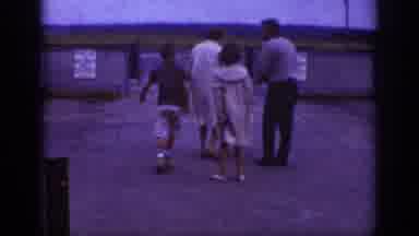 Raleigh North Carolina USA (1962): Family Of Four Walking A Dog In A Parking Lot