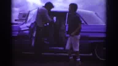 Raleigh North Carolina USA (1962): Person Getting Into Car With People Outside And