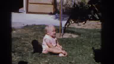 Yorba Linda California USA (1962): A Baby Sits On A Lawn With Two Small Black