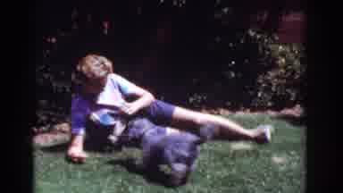 Yorba Linda California USA (1962): A Woman Laying Down On A Lawn Plays With Two