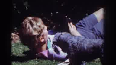 Yorba Linda California USA (1962): A Guy Lays On The Grass As He Plays With His
