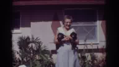 YORBA LINDA CALIFORNIA USA-1962: Woman Holding Two Puppies While Another Takes Photo