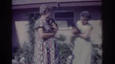 Yorba Linda California USA (1962): Women Holding Wriggling Puppies In Front Yard