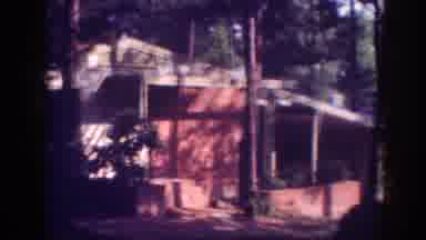Memphis Tennessee USA (1963): Red House And Blue Car In A Forest With Trees In The
