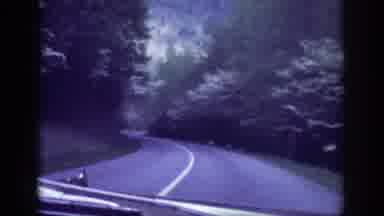 Memphis Tennessee USA (1963): A Car Is Driving Along The Road As Trees Pass On