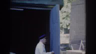 Saint Louis Missouri USA (1965): Older Gentleman In Uniform Opening A Blue Garage