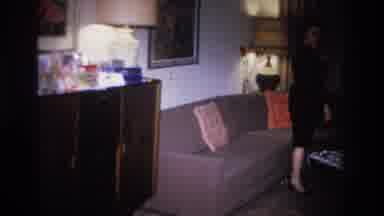 Hoboken New Jersey USA (1966): Woman Wearing Black Dress Prepares To Sit On Tan