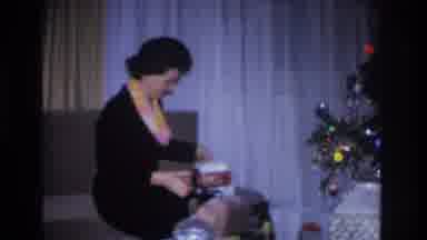 Hoboken New Jersey USA (1966): A Woman Sitting On A Couch Opening A Present Beside
