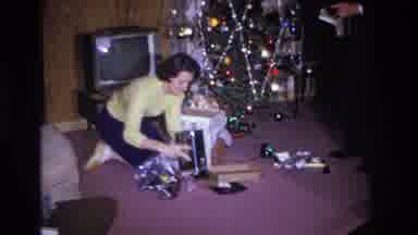 Hoboken New Jersey USA (1966): A Woman On Her Knees Opens Presents In Front Of A