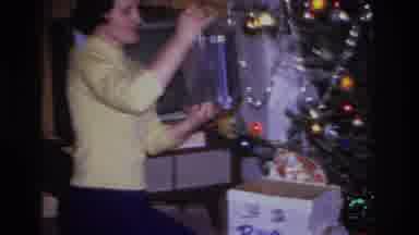 Hoboken New Jersey USA (1966): A Woman Unwrapping Presents On A Christmas Day