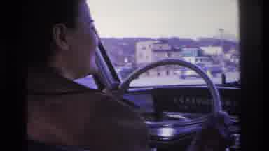 Hoboken New Jersey USA-1966: Young Woman With Hair In A Bun Driving A Car