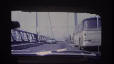 Hoboken New Jersey USA (1966): A Vehicle Drives Across A Bridge Behind A Bus