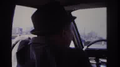 Hoboken New Jersey USA (1966): Man With A Hat On Driving A Car And Putting On