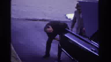 Hoboken New Jersey USA (1966): Two Men Looking At The Back Of A Black Car With