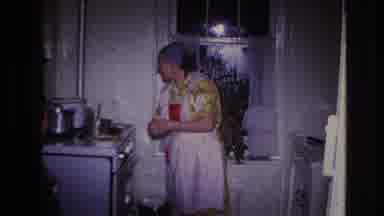 Hoboken New Jersey USA (1966): A Woman, In A Yellow Dress, Being Kept Busy In The