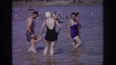 Sacramento California USA (1966): People Wading Into Lake With Child While Many