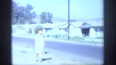 Sacramento California USA (1966): Woman In White Dress Strolling On The Sidewalk