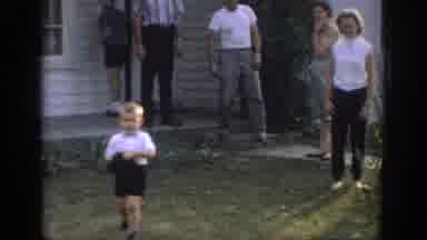Sacramento California USA (1966): Young Blonde Boy Walks Away From Family Carrying