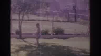 Sacramento California USA-1966: Little Boy Running Back And Forth Into A Water Sprinkler