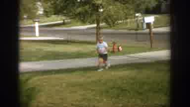 Oklahoma USA (1967): Boy Wearing Blue Shorts Running Waving Hands Stands At Door