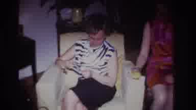 Rockaway Beach New York USA (1967): Woman Sitting On A White Couch Watching Photos
