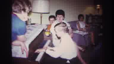 ROCKAWAY BEACH NEW YORK USA-1967: Boy Playing Piano For Family Members At Gathering