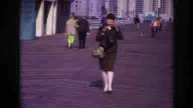Rockaway Beach New York USA (1967): A Woman Walking On The Boardwalk While Putting