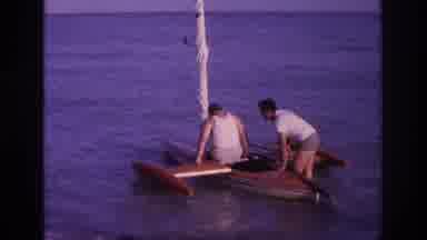 Ocean City New Jersey USA (1968): Two Men Trying To Climb Into A Red Canoe While