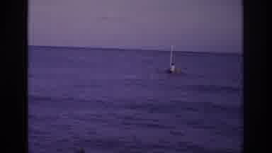 Ocean City New Jersey USA (1968): Person Paddling Raft With Sail On Calm Open
