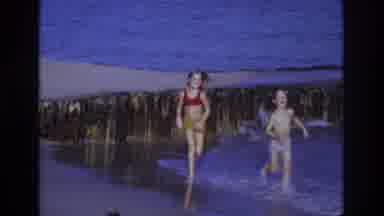 Ocean City New Jersey USA (1968): Children Running At Beach Pause To Play In Sand