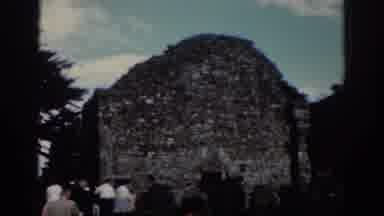 Dublin Ireland (1961): Tourists Visit A Ruins Flanked By Trees And Under A Blue