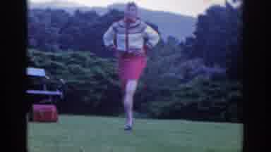 Dublin Ireland (1961): A Woman Dances On A Lawn In Front Of Trees On A Chilly Day