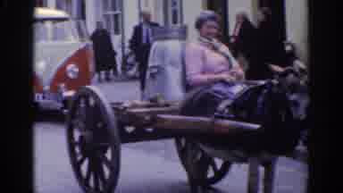 DUBLIN IRELAND-1961: Woman On Donkey Cart Passes VW Camper Van