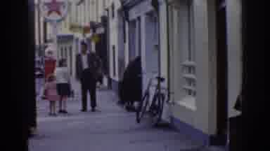Dublin Ireland (1961): People Stand And Walk Down A Sidewalk Next To A Road That