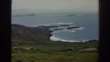 Ireland (1961): Rocky Hills Covered In Grass Slope Down To The Ocean On A Cloudy