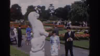 Ireland (1961): People Strolling Through A Beautiful Flower Garden Holding