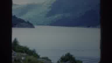 SCOTLAND-1961: Man In Red Shirt And Cap Talks About A Large Lake Surrounded By Mountains