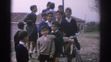 Spain (1966): A Group Of Boys Gather Around A Bike In The Shadow Of A Castle