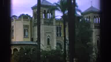Spain (1966): Large Brown Building Multiple Towers With Palm Trees And Man In Blue