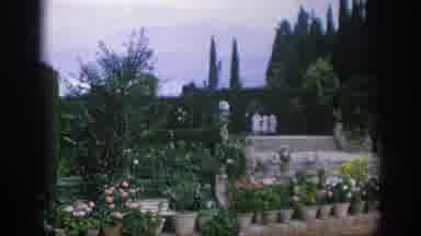 Spain (1966): A City Near Water Followed By People Walking Through Garden