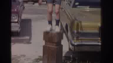 Miami Florida USA (1971): Kid Dancing On Top Of A Wooden Trunk In A Parking