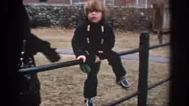 Philadephia Pennsylvania USA (1972): Mother Helps Child Over Fence By Brick