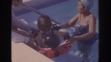 Philadephia Pennsylvania USA (1972): Parents Play With A Child In A Pool, While