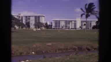 Naples Florida USA (1973): Person Recording A Setting Of Large Buildings Behind A