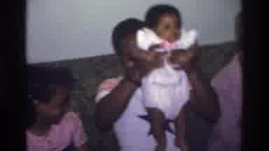 Atlanta Georgia USA (1975): A Man Trying To Please A Baby By Taking Him Up And